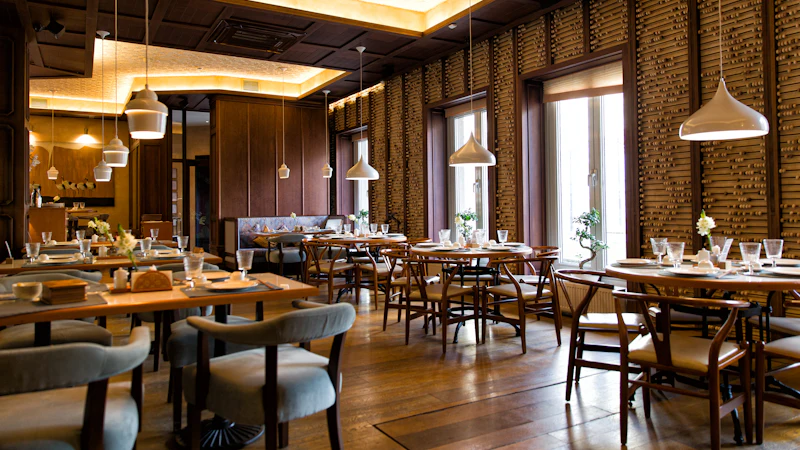 The Copper Fig dining room at dusk, warm light over wooden tables and a long bar